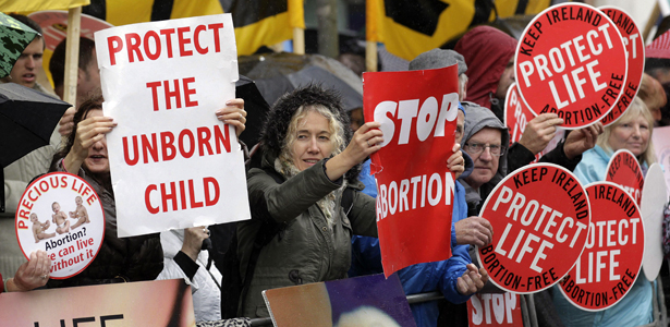 Protesters opposed to abortion hold placards outside the Marie Stopes clinic in Belfast, Northern Ireland, Thursday, 18, 2012. The first abortion clinic on the island of Ireland has opened in Belfast, sparking protests by Christian conservatives from both the Catholic and Protestant sides of Northern Irelands divide.  The Marie Stopes center plans to offer the abortion pill to women less than nine weeks pregnant _ but only if doctors determine theyre at risk of death or long-term health damage from their pregnancy.  Thats the law in both Northern Ireland and the Republic of Ireland, where abortion is otherwise illegal.    (AP Photo/Peter Morrison)