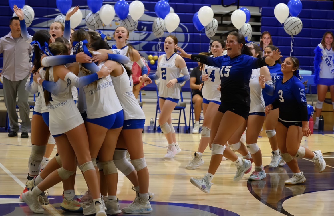 The Girls Varsity Volleyball celebrates a win against ESM

